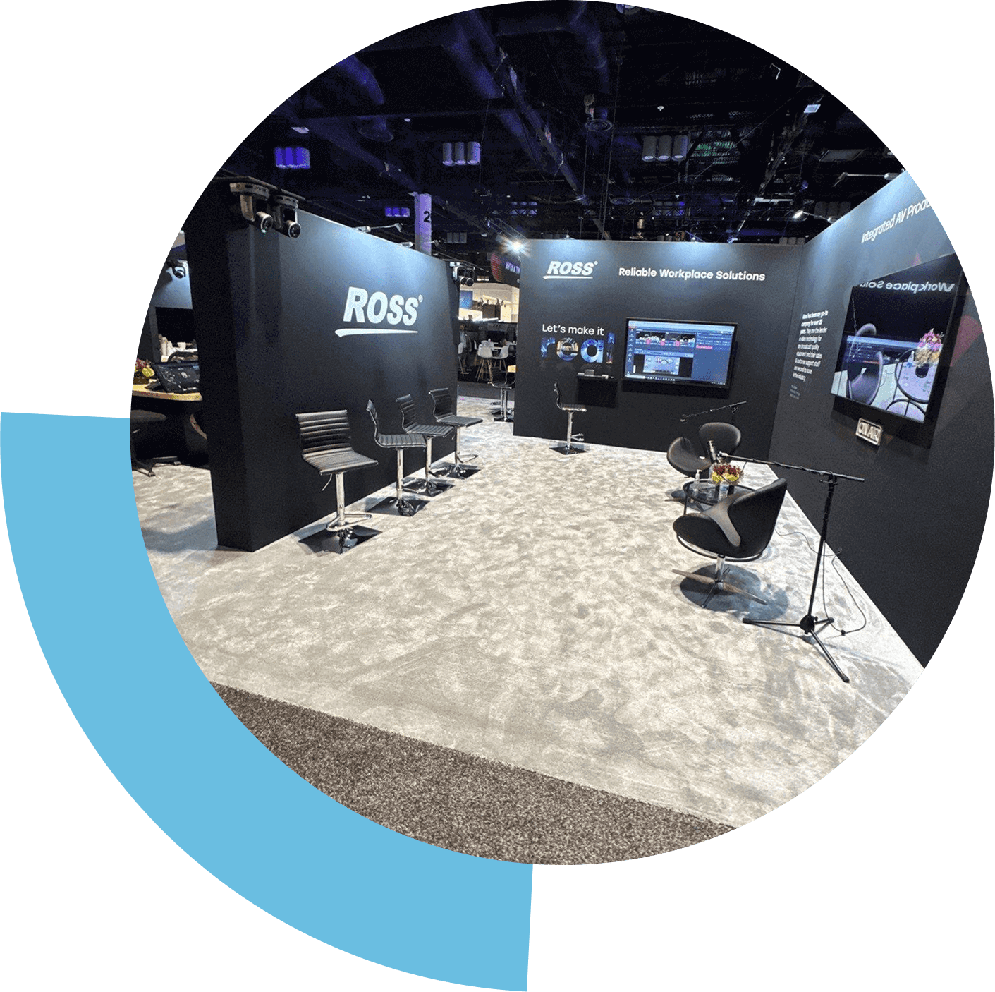 Modern exhibition booth with digital displays and seating.