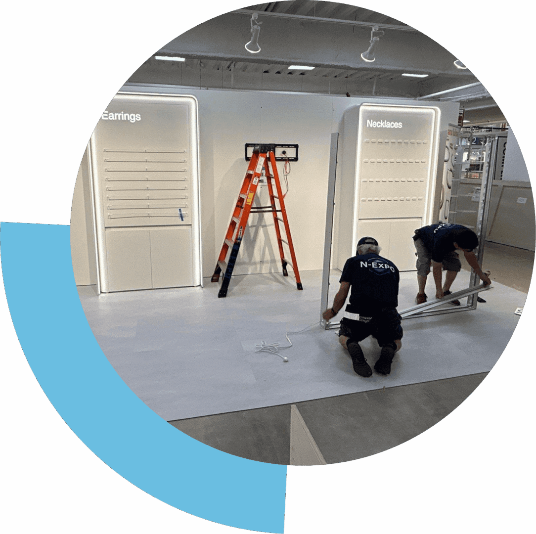Two workers installing flooring near a ladder inside a modern interior space.